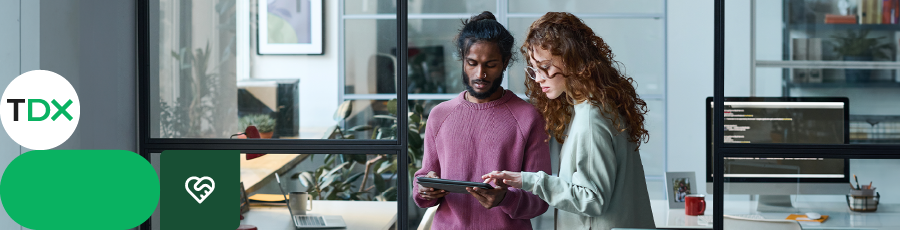 Two people standing in front of a large monitor, representing OSCP (Offensive Security Certified Professional)