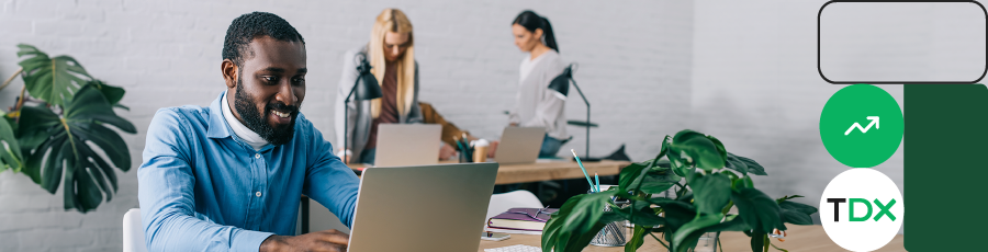 Three people working on laptops in a modern office, symbolizing Boosting Your Employability.