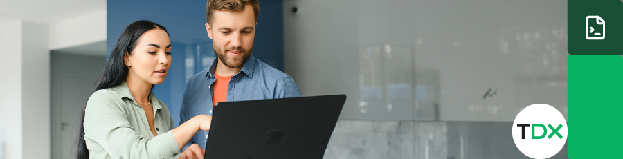 Two people discussing something on a laptop in an office, representing AWS Certified Security.