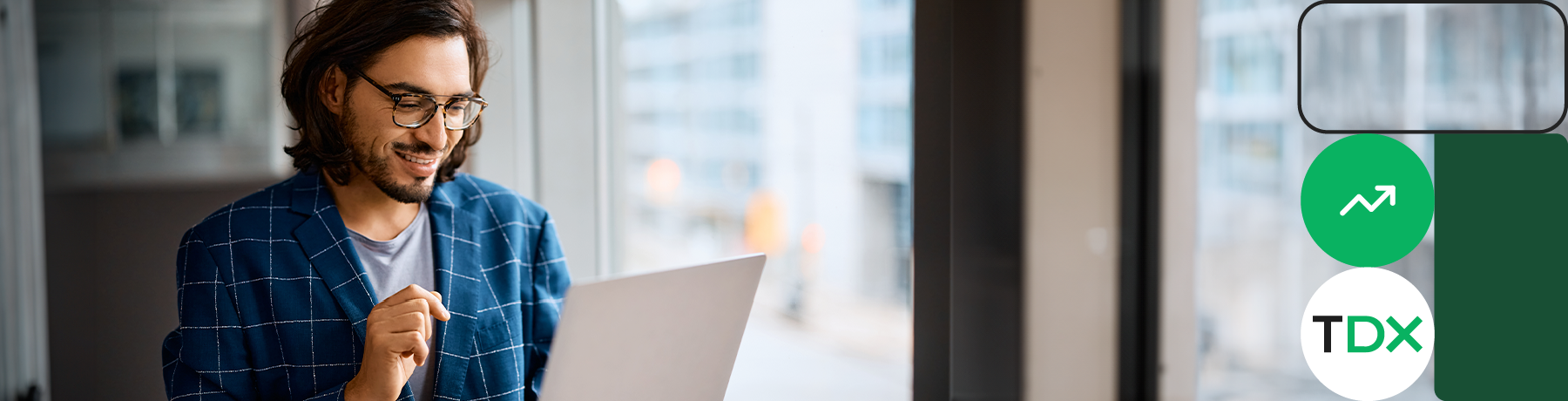 Person in a plaid shirt holding a laptop near a window