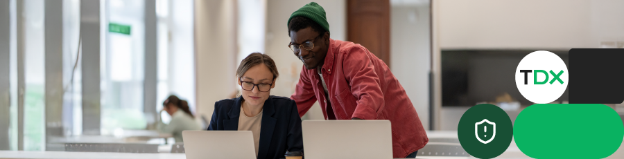 Two people working on laptops in a modern office