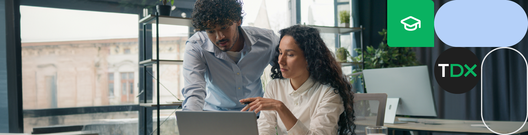 Two professionals collaborating at a laptop in a modern office setting.

